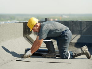 Professional roofer in Milford inspects the commercial roofing for leaks
