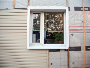 Cross-section of insulated siding showing layers of insulation and protective coating.