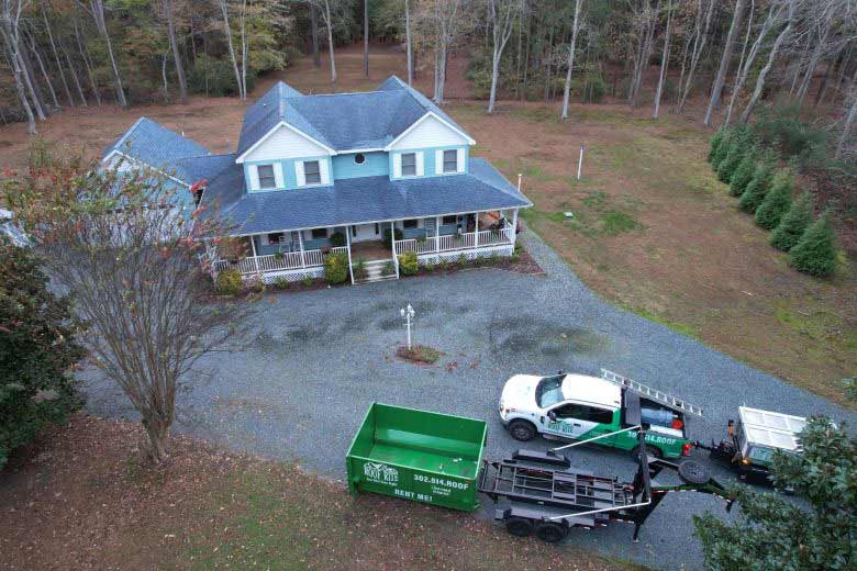 Ariel view of Roof Rite work trucks parked in front of a small and rural residential home
