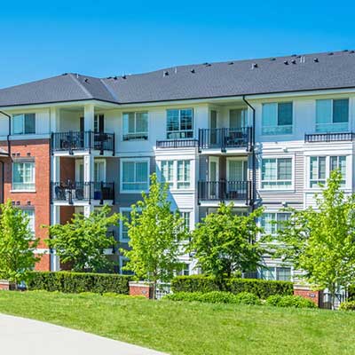 Large apartment complex building with a gray shingle roof